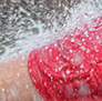 A little girl in the fountain, cooling off during a hot summer day.